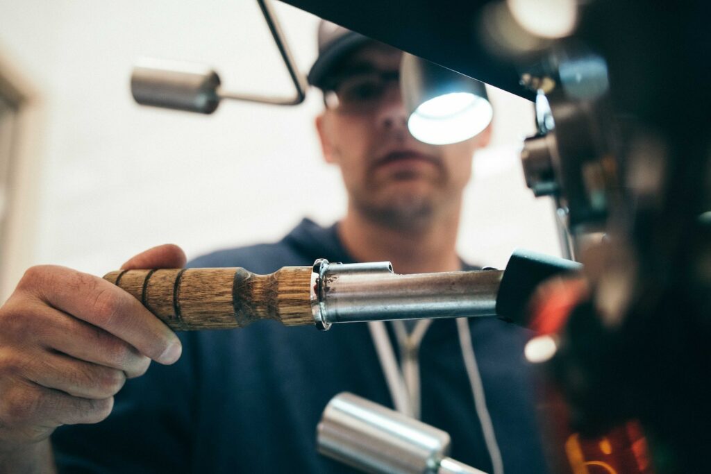 A plumber at work fixing a pipe with a tool.
